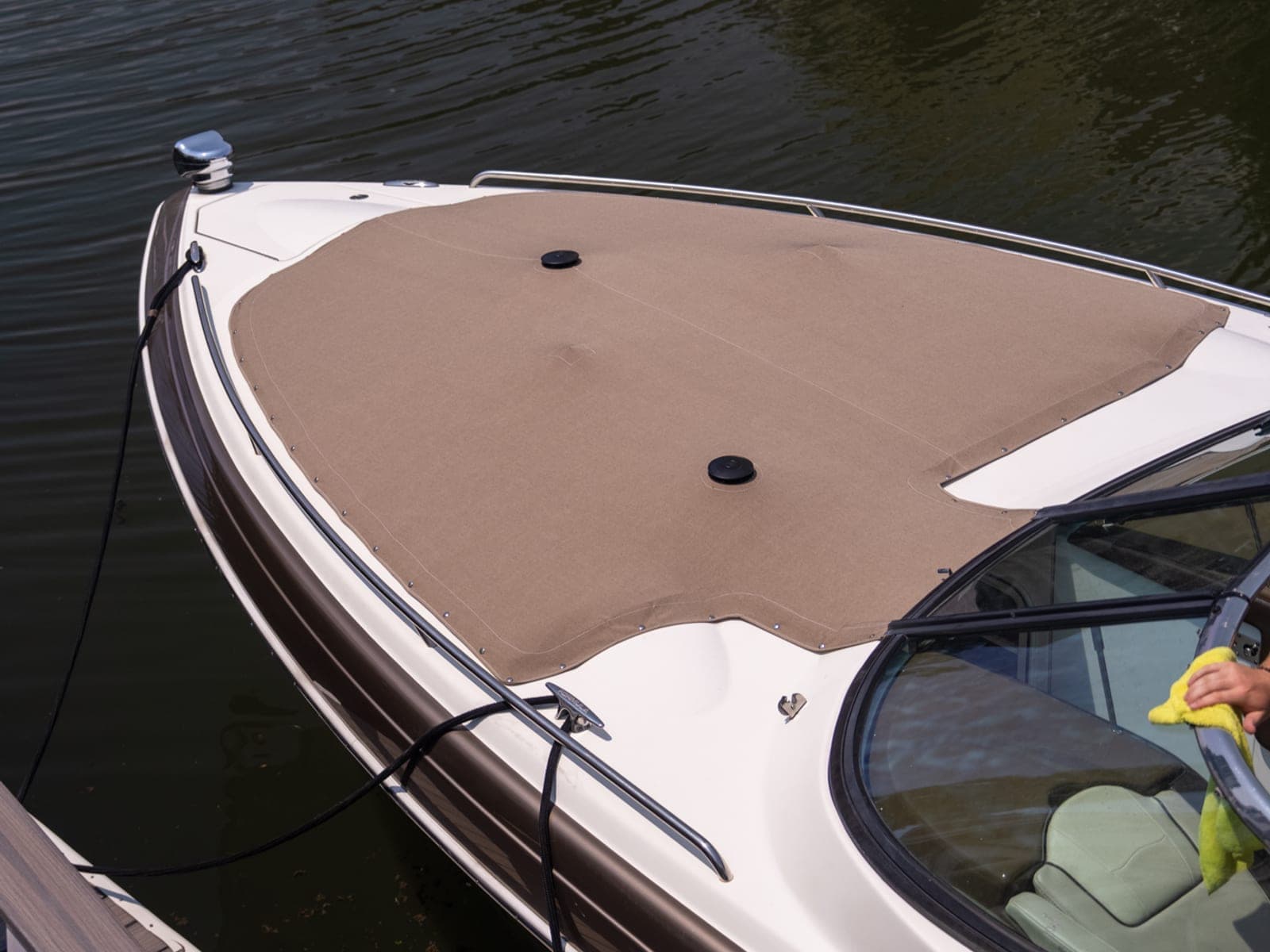 Bow of a detailed cruiser tied at a North Shore marina slip, bow cover on, dock and water visible.